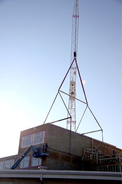 A crane lowers one of the Pembina Lodge housing modules into place. The expansion is on track and on budget.