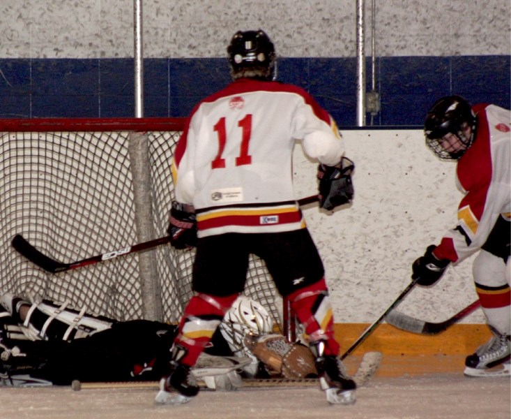 Avery Brost (11) and Madison Vekved struggle to put the puck in the net during the second period of Saturday night&#8217;s 4-4 tie with the first-place Calmar Cobras.