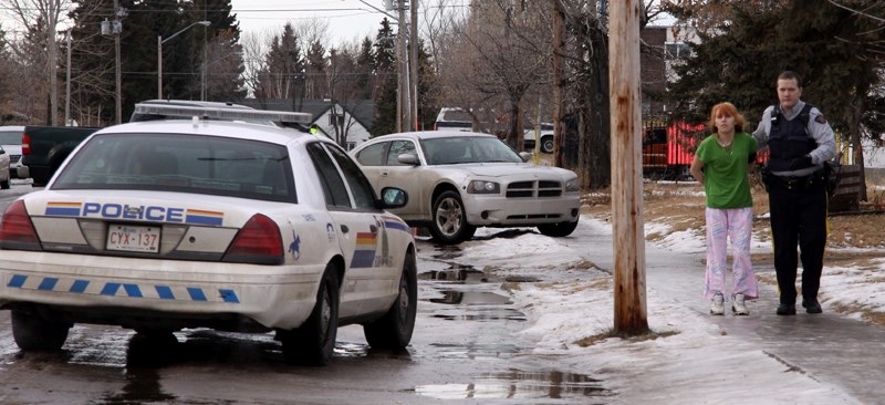 Westlock RCMP Const. Darcy Fyfe escorts Loni Nicole Byer, 22, from a residence last Wednesday. An anonymous tip put wanted man Curtis Powder, 28, at the home, which was