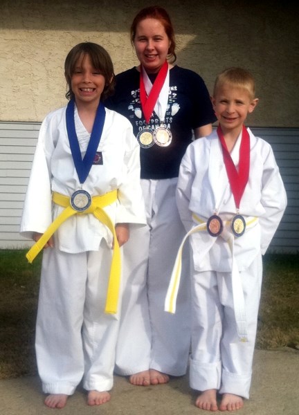 Zachary Leprine (left), Nikole Triber and Reid Pidsadowski proudly sport the medals they won at the Northern Spirit invitational taekwondo championship in Slave Lake April 28.