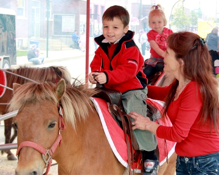Linda Russell accompanies her grandson Anthony Russell, 4, on a pony ride during Wacky Saturday.