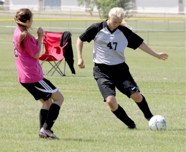 Briana Carlyon (47) works her way past an Athabasca defender in the first game of a home doubleheader on June 24.