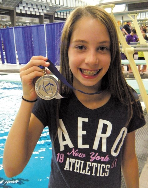 Lauren Kostiw proudly displays the silver medal she won at the ASSA provincial swim meet in the 50-metre breaststroke.