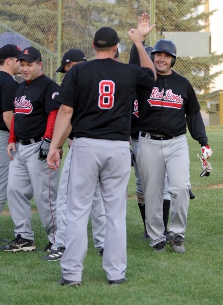 Dean Fagnan (right) gets hearty congratulations after his two-run jack against the St. Albert Cardinals Aug. 27 at Keller Field. Fagnan’s homer gave the Red Lions a 4-0 lead