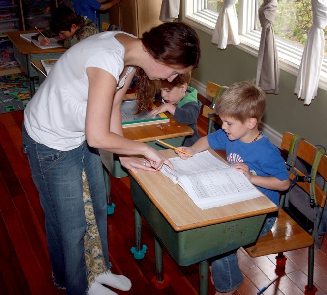 Cathy Eklund works with her two school-aged children and their three (soon to be four) siblings in their Westlock home’s living room, which has been transformed into a