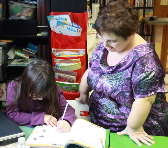 Tanya Pollard works with her daughter Mackenzie in her home classroom. Pollard, who was home schooled herself, said the experience was an overwhelmingly positive one.