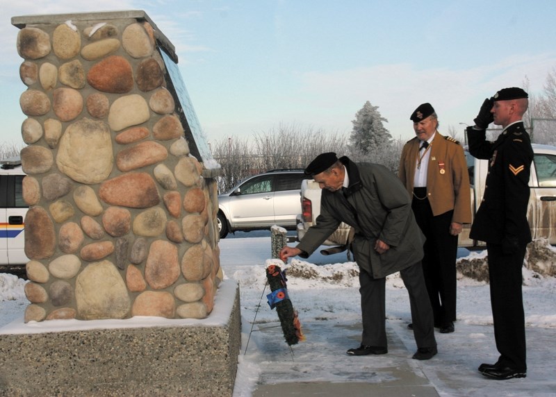 Jim Berwic pins a poppy on a wreath laid at the Clyde Cenotaph while Cpl. Keary McAtasnui of the Lord Strathcona Regiment salutes in the background and master of ceremonies