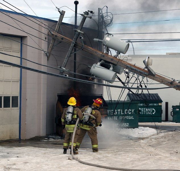 A dumpster burns after a semi truck knocked over a power pole last Wednesday behind Main Street. Power was restored later in the afternoon.