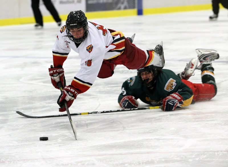 Westlock midget Warrior Tristan Tremblay fights to keep control of the puck after being upended by a Spruce Grove Bandit in the final of the Gord Smith Memorial Tournament on 