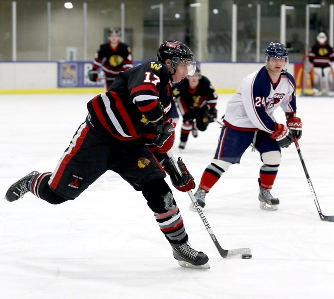 Edmonton Beverly Warrior Luke Pavlic (17) fires a shot on net in front of the Spruce Grove Regals’ Zack Mills (24) during the Junior