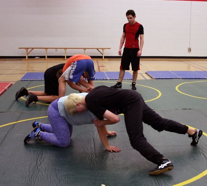 Haley Heffel (front, underneath) practises wresting technique with a sparring partner at practice on Feb. 6 at R.F. Staples. Heffel earned a gold at a U of A wrestling