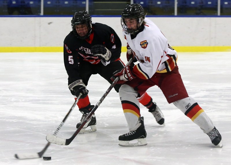 Warrior Tristan Tremblay (right) fights for control of the puck against Vegreville last Friday.
