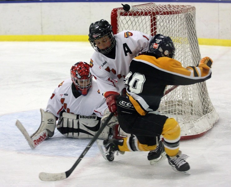 Westlock Atom Warrior Brenden Gerig tries to defend his net against a Stony Plain Predator while goalie Josh Fagnan looks on during Tuesday’s home game at the Rotary Spirit