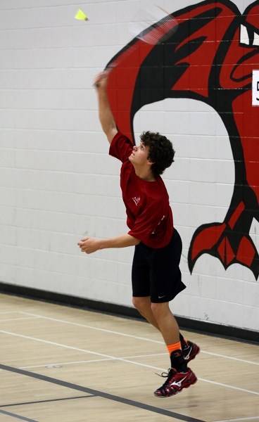 R.F. Staples’ Patrick Frose delivers an overhead smash in junior boys singles action during the conference badminton tournament April 18.