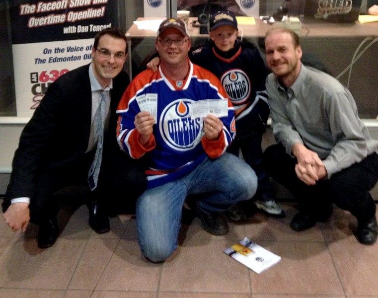 Mike Edwards (centre-left) and his son Isaac show off the cheque for $57,000 they won in the 50/50 draw at the April 16 Oilers game at Rexall Place. With Edwards are CHED’s