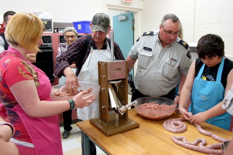 L-R: Aarin Merkel, Gordon Lockwood, Westlock RCMP Staff Sgt. Dwayne Rawson and Travis Guest spent a half day making sausages from scratch on May 14. The Westlock RCMP