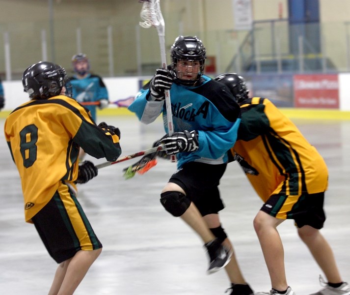 Bantam Rock’s James McCabe splits a pair of Sherwood Park Titans during the club’s 15-8 Wednesday-night loss in the GELC final held in Edmonton. To make the final the team