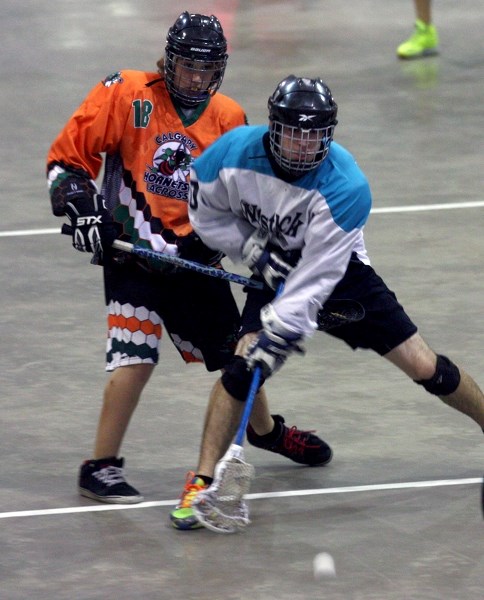 Midget Rock&#8217;s Jacob Grainger battles a Calgary Hornet opponent during the Rock&#8217;s 7-5 Saturday afternoon win during the round robin portion of the Midget