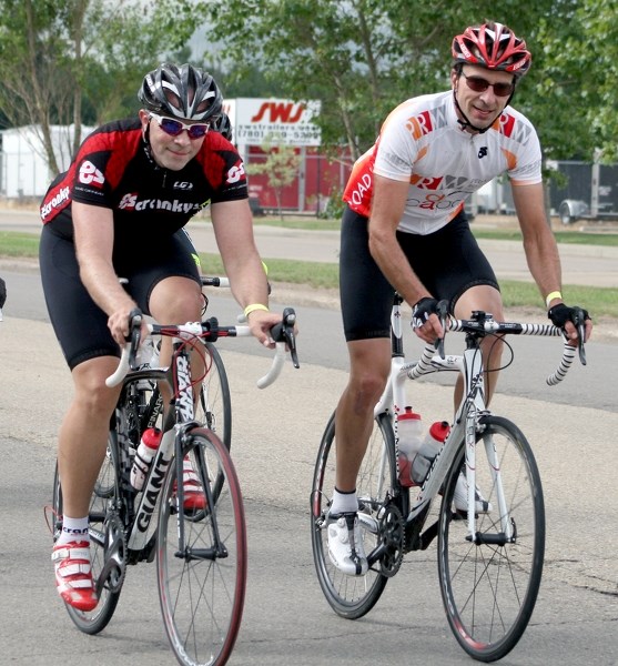 A pair of riders roll into town during Sunday’s 185-kilometre Tour de l’Alberta.