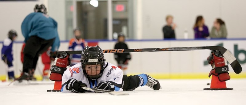 Kohyn Pipke slides under a hockey stick as part of the obstacle course at the Oct. 5 I Love Hockey event at the Westlock Rotary Spirit Centre. The annual event is designed to 