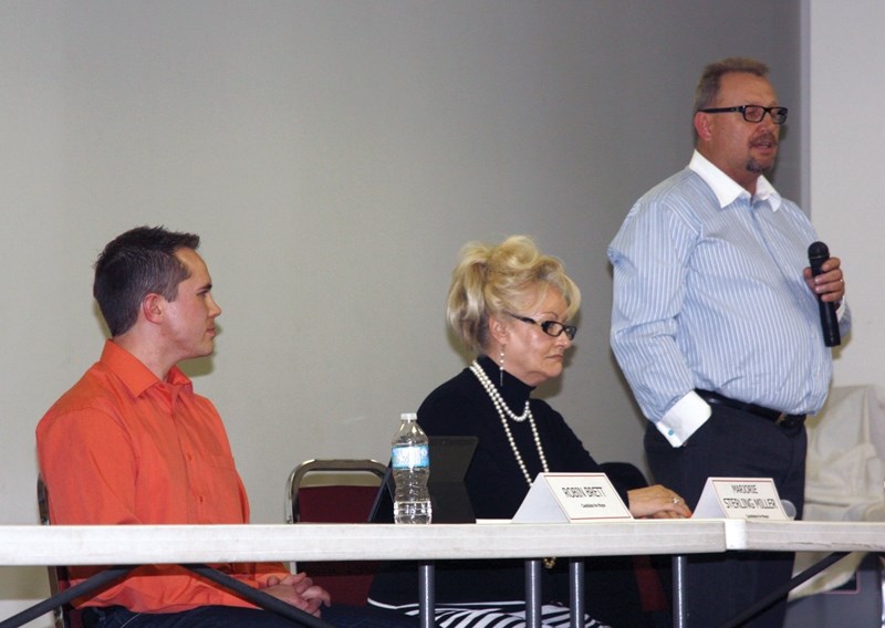 Ralph Leriger speaks to the crowd at the Oct. 9 forum about why he should be chosen as mayor while candidates Robin Brett and Marjorie Sterling Miller look on.