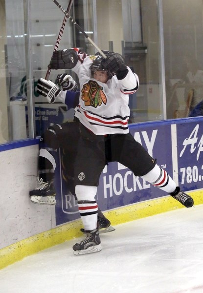 Westlock Warrior Derek Koizumi lays a hit on an Edson Ice player in the third period of the Warriors’ season and home opener Oct. 19 at the Westlock Rotary Spirit Centre. It