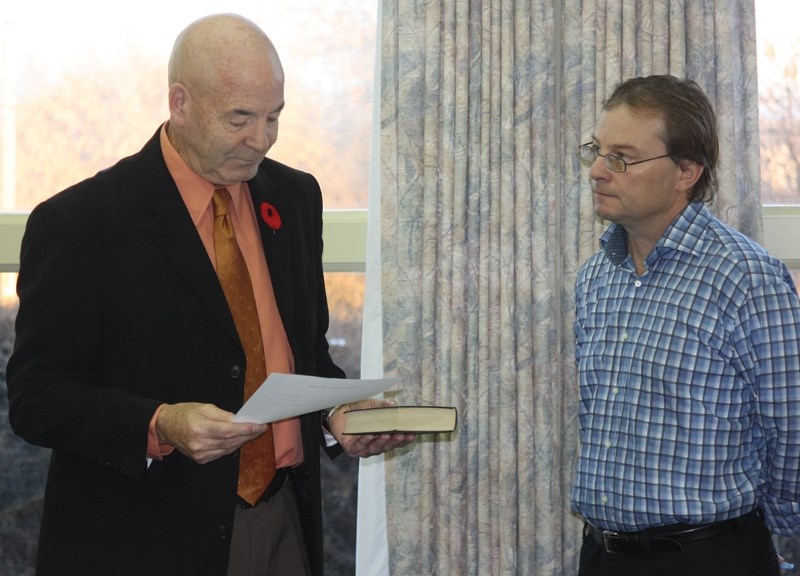 Bud Massey takes his oath as the new reeve of Westlock County as CAO Ed LeBlanc looks on Oct. 29.
