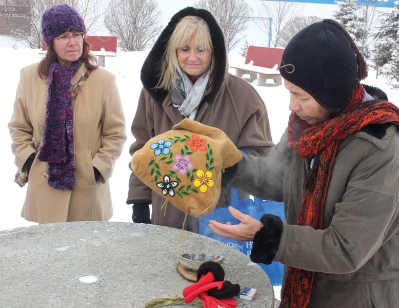 Dawn Rouncville (left) and Hope Resource Centre manager Sylvia Yoder watch and listen as Alice (right), an aboriginal elder, explains the purpose of the smudging ceremony