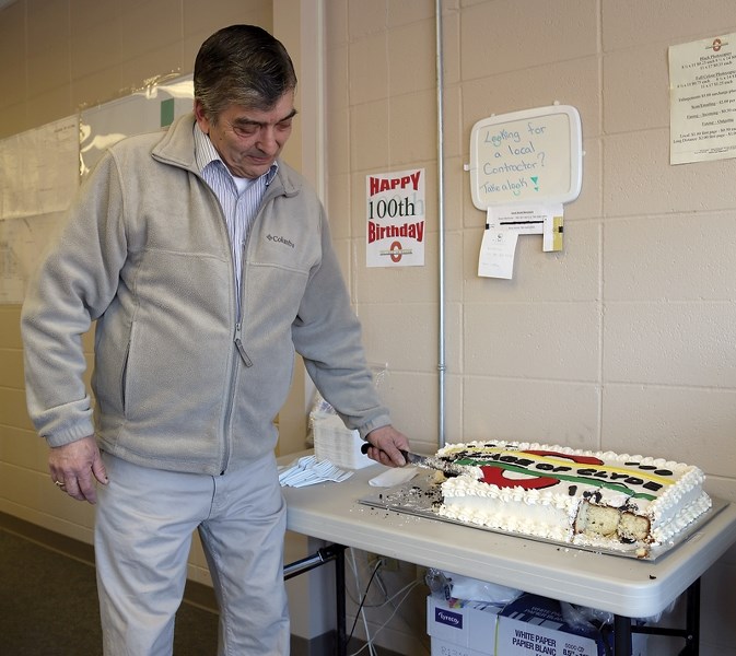 Village of Clyde deputy mayor Nat Dvernichuk cuts a piece out of the cake marking the municipality’s 100th anniversary on Jan. 28. A bigger 100th anniversary celebration is