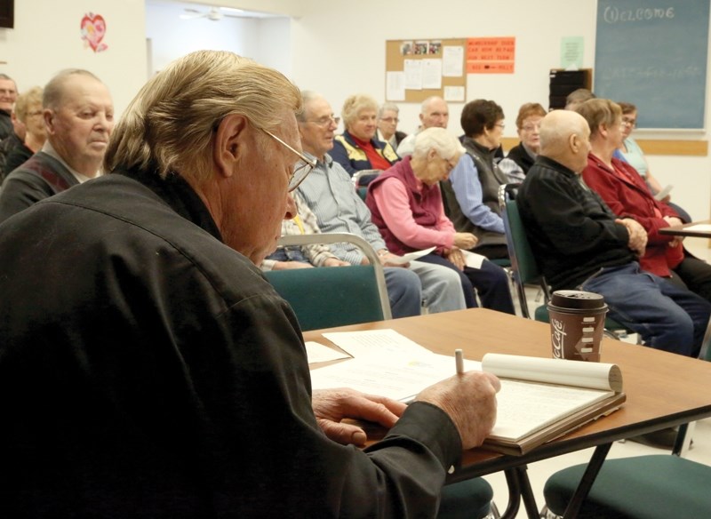 Larry Lang (foreground) makes notes while listening to concerns from seniors at the Golden Age Drop-in Centre. Lang was in Westlock on Feb. 12 with the Seniors Advisory