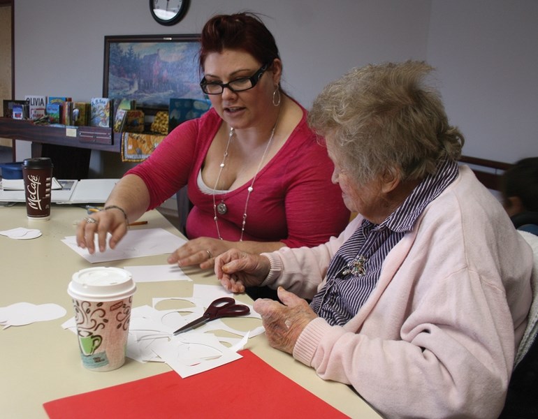 Each One Teach One Literacy Society facilitator Deonne Dranchuk (left) works with Westlock Continuing Care Centre resident Rena Swanson to build a story sack based on the