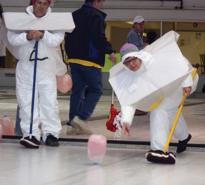 Sherrie Soch, dressed up as a milk carton, throws one of the makeshift rocks used in the inaugural Crazy Curling Jugspiel last Saturday afternoon. The event, which organizers 