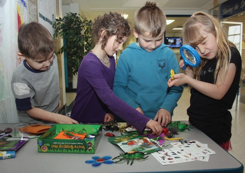 From left, St. Mary School students Chazz Mainland, Abigail Mosher, Owen Hartman and Nevaeha Woodcock take a look at the model bugs in one of the reading pods that will take