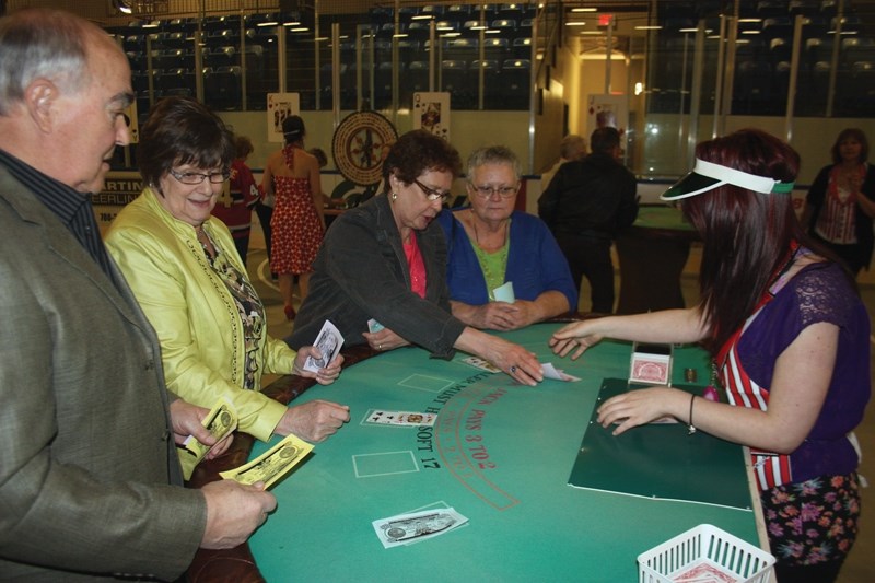 Volunteers (L-R) Chuck Keller, Gloria Johnson, Elaine Colbourne and Wanda McMillan collect some winnings after dealer Merissa Lalonde goes bust at the volunteer appreciation