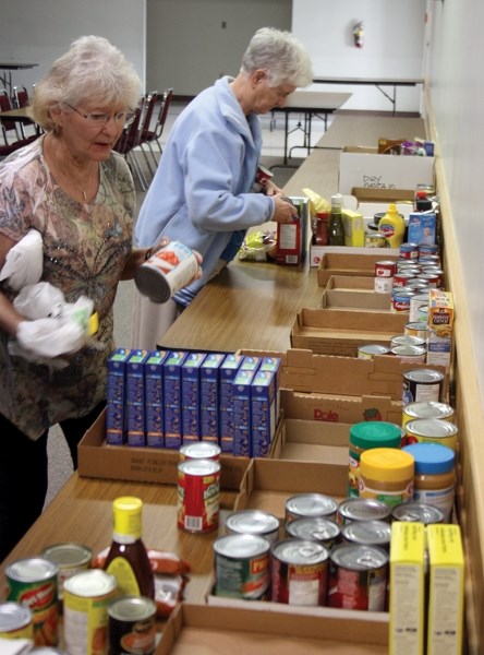 Westlock Food Bank volunteers Helen Haas (left) and Sister Eileen Boyle sorted donations as they came in last Thursday evening. May 5-9 is Hunger Awareness Week across Canada.
