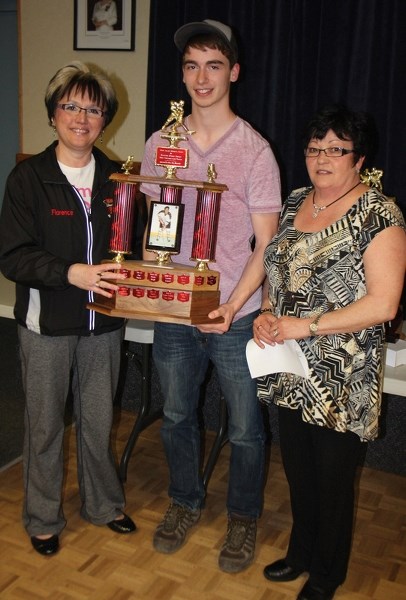 Florence Waldner (left) and Joan Jolliffe present the Derek Jolliffe Sportsman Trophy to Cole Walker at the April 29 Westlock and District Minor Hockey awards night.
