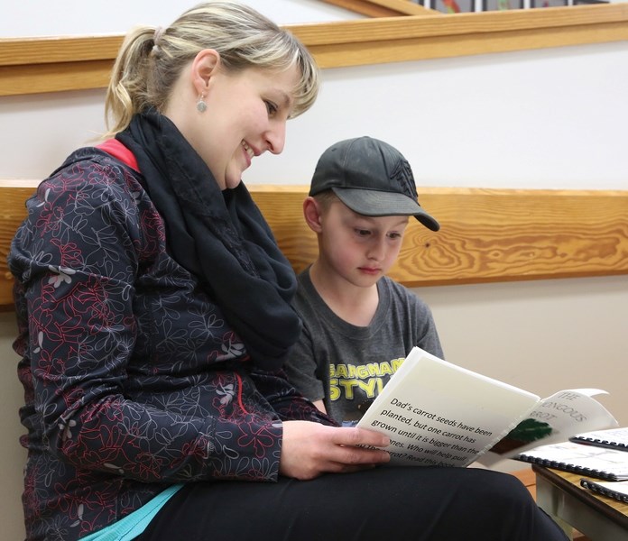 Kruz Woodcock (right) reads Preston Bruens’ book The Humongous Carrot to his mom Francine at the May 8 Busby Author’s Night at Busby School. The night is a chance for the