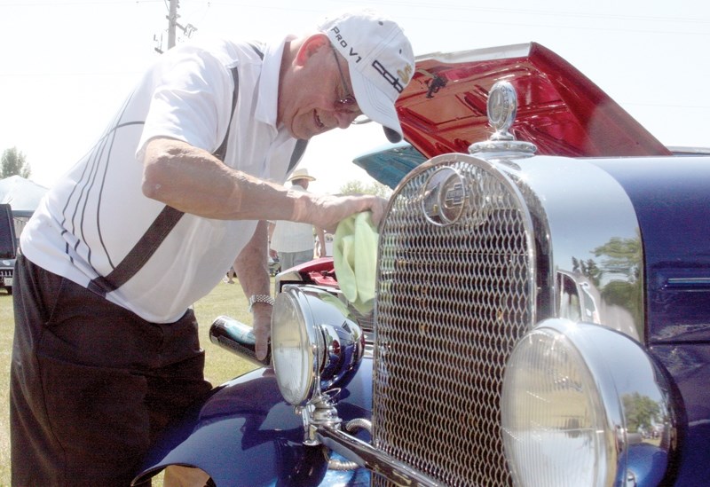 Ed Zawada polishes the chrome and cleans the bugs off his 1928 Chevy Landau Coupe after the drive from Edmonton to the Westlock Wheels of Class Show &#038; Shine last Sunday