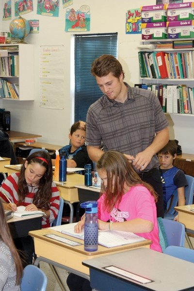Mike Ivey looks over the shoulder of one of his students at Busby School on Oct. 20. Ivey, who teachers the Grade 5-6 class at Busby, is one of 28 new teachers in the Pembina 