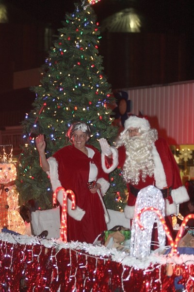 Santa and Mrs. Claus wave to the crowd from a parade float during Friday&#8217;s Light Up. More than 1,000 people took in the annual pre-Christmas festival.