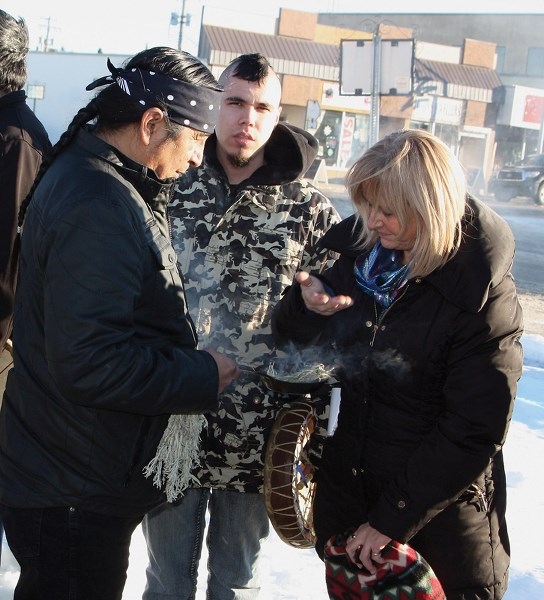 Sylvia Yoder takes part in a Dec. 11 cleansing ceremony performed by Willard Alexis.