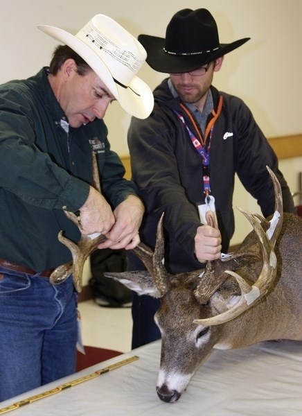 Scorer Bob Daudelin and volunteer Jesse Nelson measure a set of whitetail antlers brought in by Kevin From at the Busby Fish &#038; Game Association’s seventh annual Antler