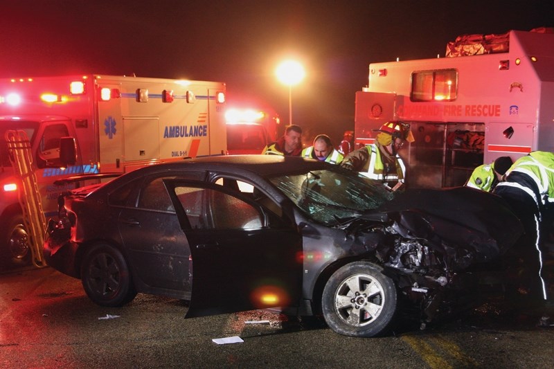 Firefighters attempt to extricate the driver of a Chevrolet Impala involved in a two-vehicle collision along Highway 18 near the turnoff to the Westlock Golf Club. Driving