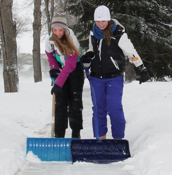 Leanne Kohlsmith and Michele L’Heurnux teamed up Friday to clear a sidewalk on 102nd Avenue. The long-range Environment Canada forecast calls for warmer temps and more