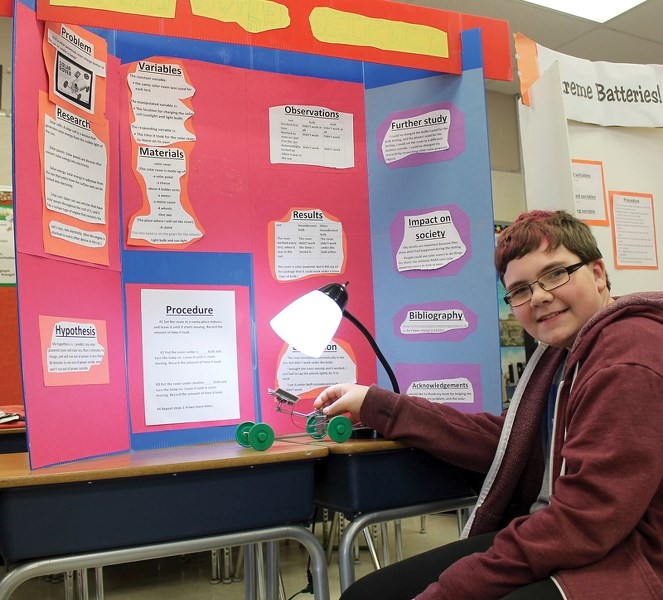 Grade 6 St. Mary School student Ethan Hartman demonstrates that a fluorescent light bulb is insufficient to power his solar car. Children from Grades 4, 5 and 6 showed off
