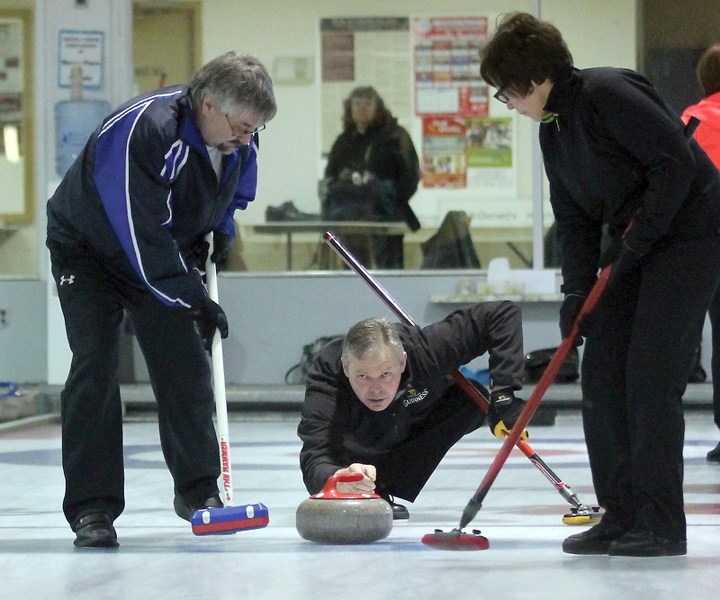 Terry Sheehan, assisted by sweepers Barry Dennis and Pauline Ruxton, is a picture of focus and concentration during the semifinal of the recent Westlock Curling Club Mixed