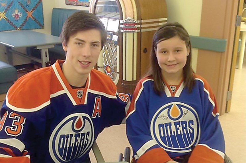 Andrea Nickerson poses for a photo with Edmonton Oiler Ryan Nugent-Hopkins at Glenrose Rehabilitation Hospital in Edmonton in 2013. Nickerson’s family is in the midst of a