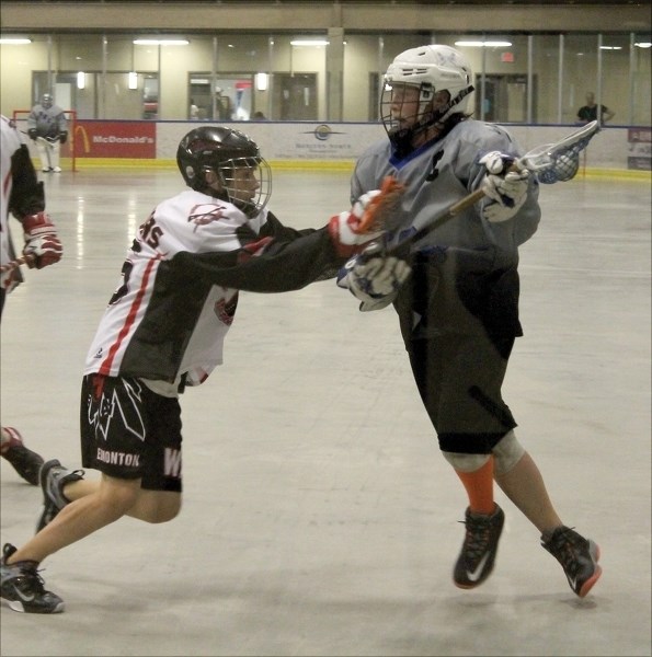 Bantam Rock player Cole Perkins stands strong in the face of some aggressive checking during the first of two wins over the South Edmonton Warriors at the Spirit Centre on