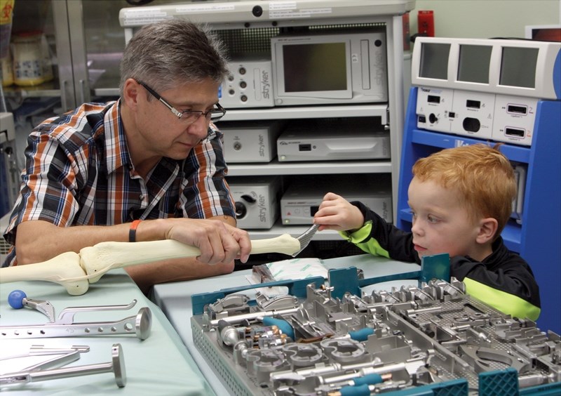 Three-year-old Blake Thomaser gets a first-hand look at some surgical instruments with Dr. Jan Lategan in the operating room during a May 30 open house of the Westlock