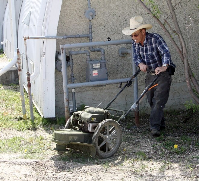 Jim Cox takes care of some weeds during the Busby community clean up on May 31. Members of the community mowed grass and picked up trash as part of the effort.